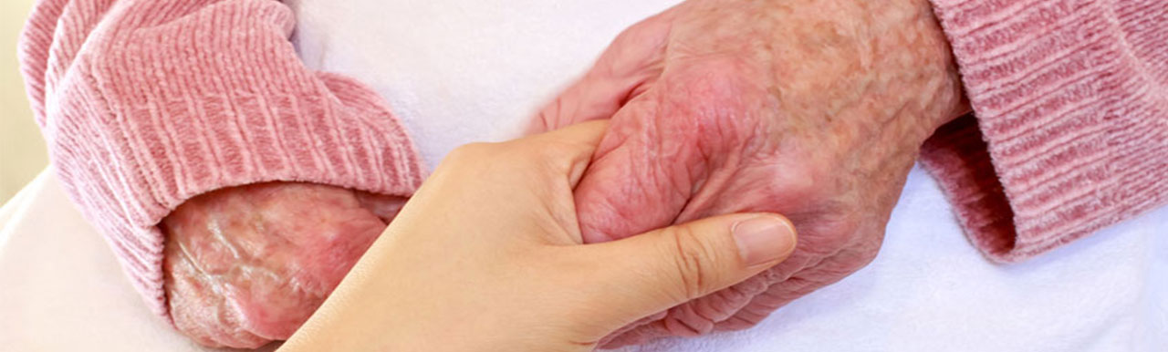 Caregiver holding senior citizen's hands