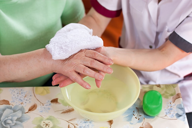 Caregiver washing elderly woman's hand in Lancaster & York, PA