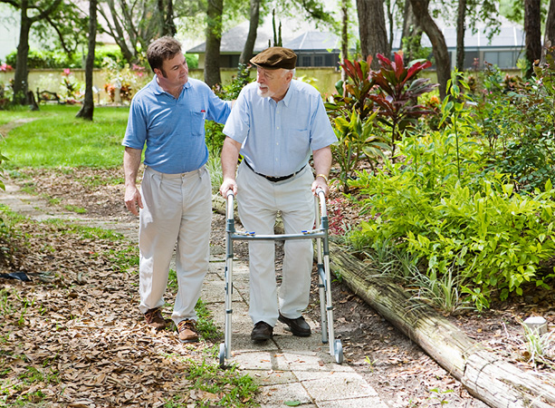 Alzheimer Patient and Caregiver Walking Through Garden