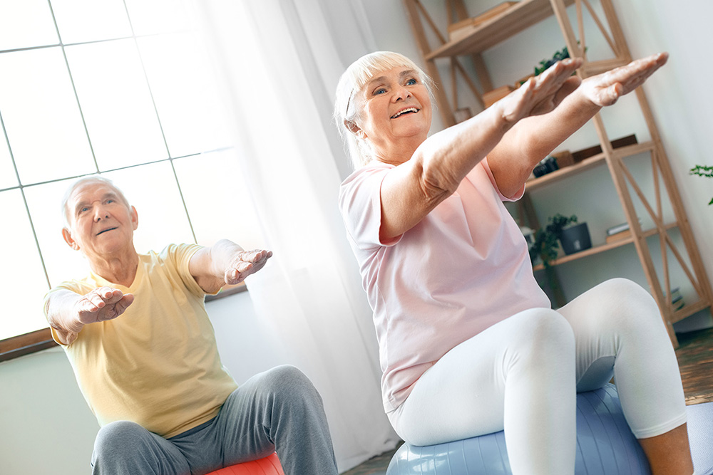 Elderly Couple Exercising Together on Balls